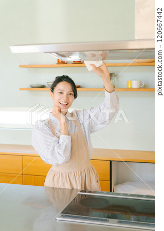 Woman cleaning the ventilation fan in the kitchen Woman cleaning the ventilation fan in the kitchen 120667442