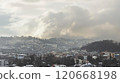 Winter scene, snow covered houses and trees under a dramatic sky with dark clouds in a residential area 120668198