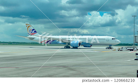 Large passenger airliner is taxiing on the runway, preparing for takeoff or after landing, under a cloudy sky Large passenger airliner is taxiing on the runway, preparing for takeoff or after landing, under a cloudy sky 120668210