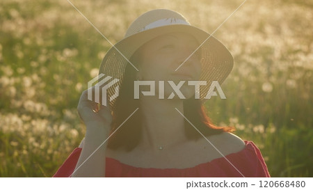 Amazing Nature. Attractive Woman In Summer Dress And Hat On Field Against Beautiful Sunset. Close Up. Amazing Nature. Attractive Woman In Summer Dress And Hat On Field Against Beautiful Sunset. Close Up. 120668480