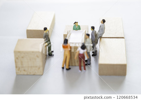 Miniature people discussing around a table 120668534