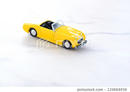 Image of a leisurely road trip in a yellow two-seater convertible 120668936