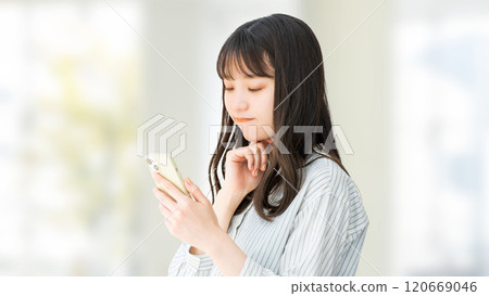 一位女商人看著她的智慧型手機並思考 一位女商人看著她的智慧型手機並思考 120669046