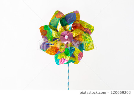 Close-up of holographic pinwheel set against white backdrop with space for text. Bright summer, childhood, and playful design concept suited for print, digital design, and marketing visuals, 120669203