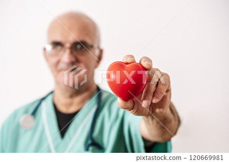 Doctor holding heart on white empty background. Cardiology, care about the heart and health 120669981