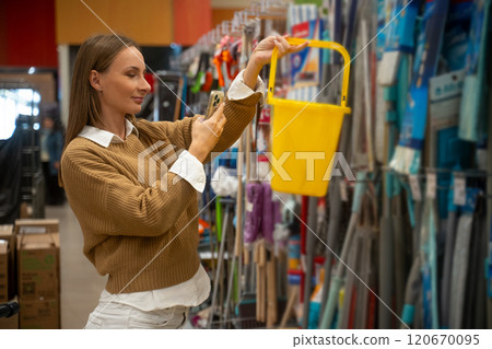 Explore the aisles as a woman scans products with her smartphone in a colorful store 120670095