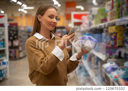 Scanning wipes with a smartphone at a grocery store for easy shopping and product information Scanning wipes with a smartphone at a grocery store for easy shopping and product information 120670102