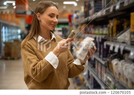 Scanning grocery labels with a smartphone in a supermarket aisle Scanning grocery labels with a smartphone in a supermarket aisle 120670105