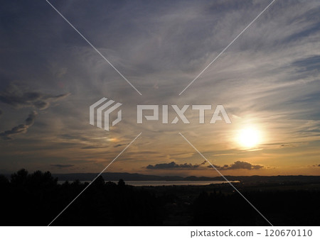橘色的夕陽像火球,豬苗代湖上空的雲彩閃爍著彩虹般的色彩。它令人印象深刻且美麗。 橘色的夕陽像火球,豬苗代湖上空的雲彩閃爍著彩虹般的色彩。它令人印象深刻且美麗。 120670110