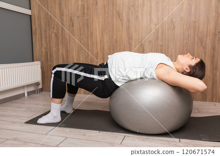 Pregnant woman exercising with yoga ball indoors 120671574