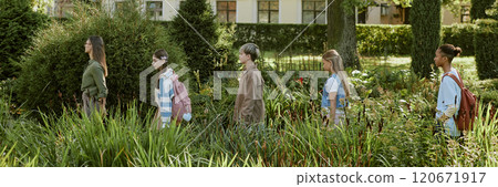 Side view of teenagers following their young teacher, walking along local botanical garden during outdoor lesson, header for website Side view of teenagers following their young teacher, walking along local botanical garden during outdoor lesson, header for website 120671917