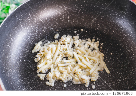 Melting cheese in a frying pan Melting cheese in a frying pan 120671963