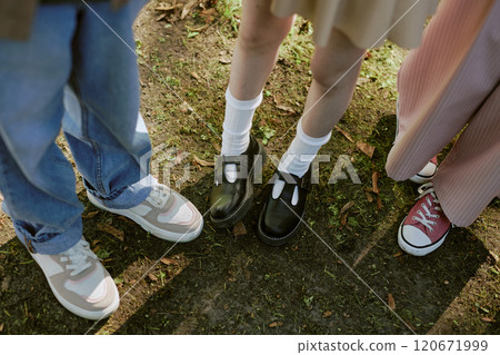 High angle view of legs of unrecognizable teen boy and girls standing outdoors 120671999