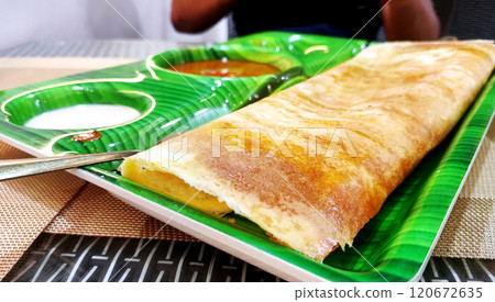 South indian food crispy Masala Dosa with sambar and chutney on banana leaf style plate 120672635