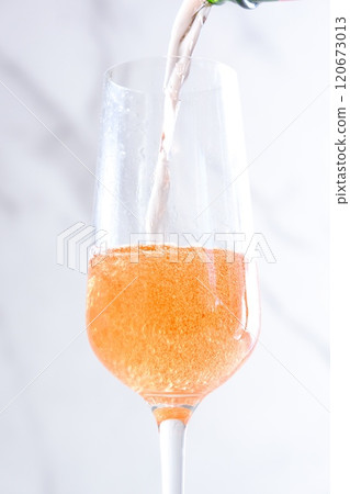 將冷藏好的桃紅香檳(起泡酒)倒入長笛杯中 將冷藏好的桃紅香檳(起泡酒)倒入長笛杯中 120673013