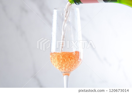 將冷藏好的桃紅香檳(起泡酒)倒入長笛杯中 將冷藏好的桃紅香檳(起泡酒)倒入長笛杯中 120673014