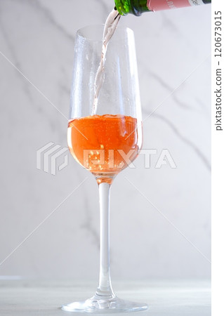 Pour well-chilled rosé champagne (sparkling wine) into a flute glass Pour well-chilled rosé champagne (sparkling wine) into a flute glass 120673015
