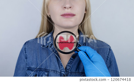 Thyroid disease - hyperthyroidism. The doctor examines the patient's thyroid gland with a diagnosis written on it through a magnifying glass Thyroid disease - hyperthyroidism. The doctor examines the patient's thyroid gland with a diagnosis written on it through a magnifying glass 120674418