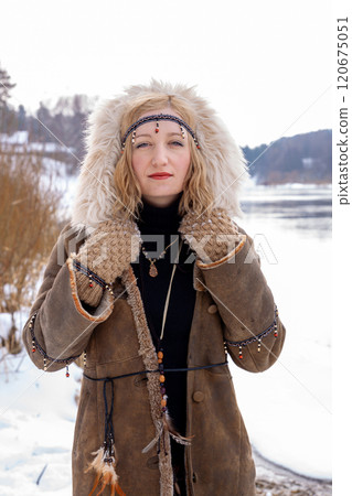 A young woman with blonde hair dressed in a warm fur-lined leather coat A young woman with blonde hair dressed in a warm fur-lined leather coat 120675051