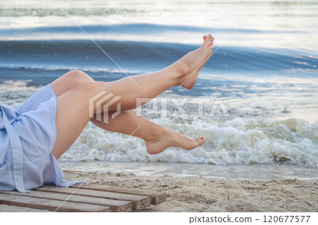 Woman's beautiful legs on the beach 120677577