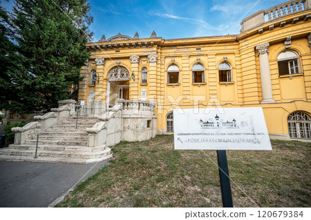 Budapest, Hungary. August 27, 2022. Shot at the main entrance of the Szechenyi Baths, the largest in the city. An information sign points to it. Travel destinations, beautiful summer day. 120679384
