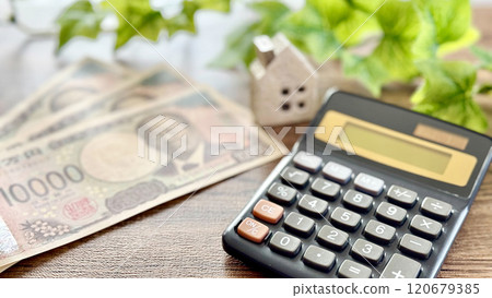三張新的10,000日圓鈔票、家居用品和計算器_棕板背景 120679385