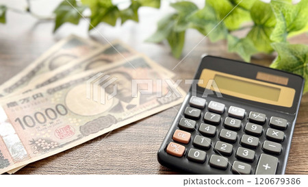 三張新的10,000日元鈔票和計算器_棕板背景 120679386