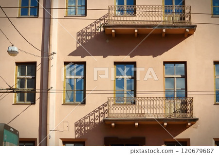 An old balconies casting shadows on brown building in old town with many wires over the road on this street An old balconies casting shadows on brown building in old town with many wires over the road on this street 120679687