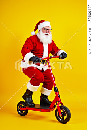 A man dressed as Santa Claus riding a red scooter on a yellow background 120680145