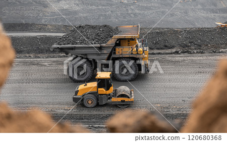 Large quarry dump truck. Big yellow mining truck at work site. Loading coal into body truck. Production useful minerals. Mining truck mining machinery to transport coal from open-pit production 120680368