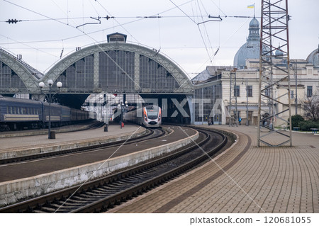 Modern Train Approaching Historic Railway Station 120681055