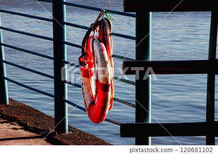 Red and White Lifebuoy Hanging on a Rail. Red and White Lifebuoy Hanging on a Rail. 120681102