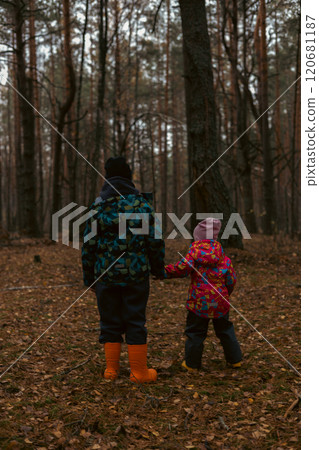 Two lost children in jackets and rubber boots hold on to mysterious autumn forests, in search of an exit. Bret and his sister were lost in the forest and wandered in circles in search of help. 120681187