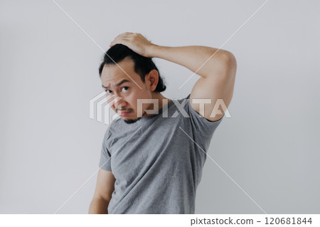 Man in grey t-shirt feels shocked with his bald hair. Hair falls problem. Man in grey t-shirt feels shocked with his bald hair. Hair falls problem. 120681844