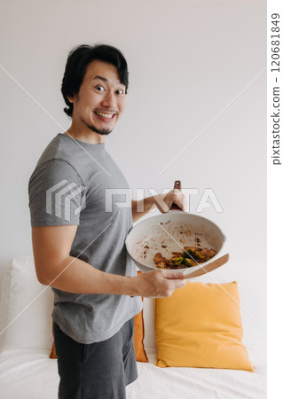 Vertical photo of happy man presents and offering his meal in the pan. Vertical photo of happy man presents and offering his meal in the pan. 120681849