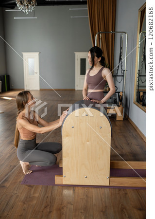A Pilates instructor diligently preparing the Barrel equipment for an upcoming session A Pilates instructor diligently preparing the Barrel equipment for an upcoming session 120682168