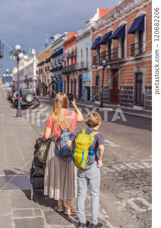 Mother tourist with her toddler and teenage sons walking through the colorful colonial streets of Puebla, Mexico. Travel, cultural exploration, and vibrant architecture concept 120682206