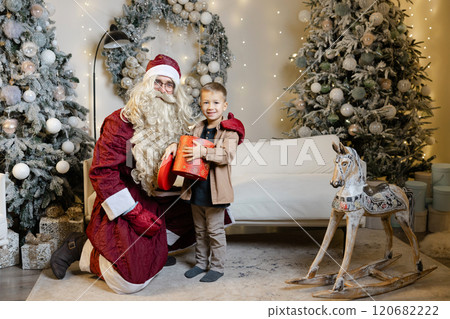 Santa claus giving christmas gift to child Santa claus giving christmas gift to child 120682222