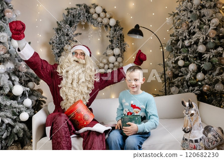 Santa claus giving christmas gift to a happy child Santa claus giving christmas gift to a happy child 120682230