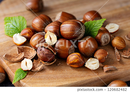 Hazelnuts pile on a wooden board 120682482