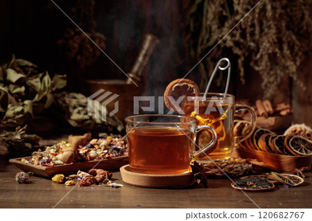 Cups of herbal tea with various dried herbs, flowers, and spices. 120682767