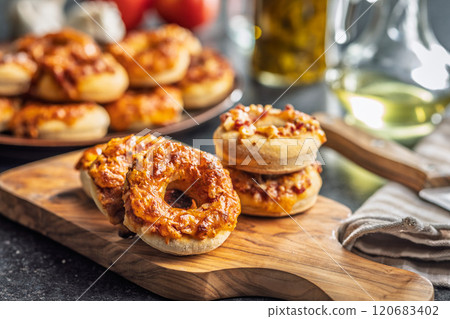 Mini pizza bagels on cutting board on black table. 120683402