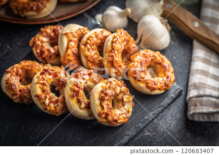 Mini pizza bagels on cutting board on black table. Mini pizza bagels on cutting board on black table. 120683407
