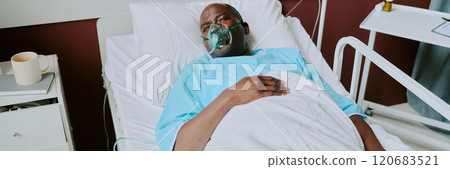 African American elderly man lying in hospital bed with oxygen mask, appearing resting African American elderly man lying in hospital bed with oxygen mask, appearing resting 120683521