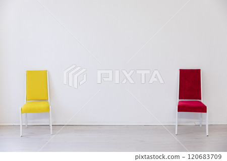 Two multicolored chairs in the interior of an empty white room 120683709