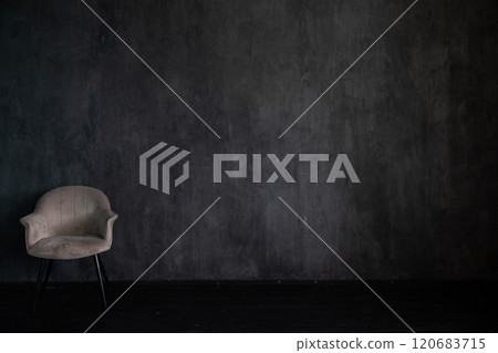Armchair alone in the interior of an empty gray room 120683715