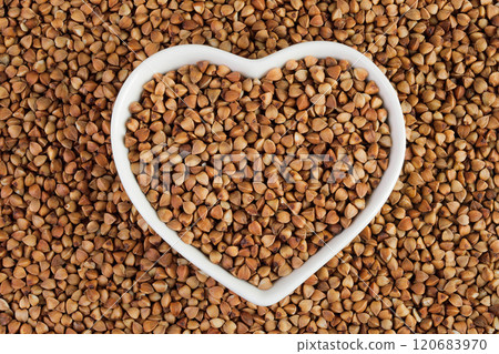 Raw buckwheat in ceramic bowl as a background. Top view. Flat lay 120683970