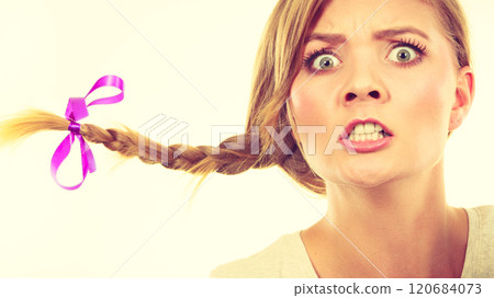 Teenage girl in braid hair making angry face 120684073