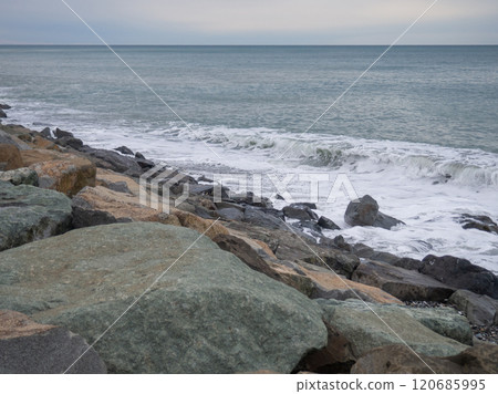 resort in winter. The rocky shore is washed by the waves in cloudy weather. Black Sea coast. The coast of Batumi. Nature in shades of grey. boring landscape resort in winter. The rocky shore is washed by the waves in cloudy weather. Black Sea coast. The coast of Batumi. Nature in shades of grey. boring landscape 120685995