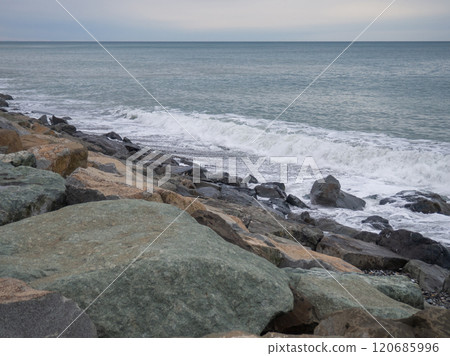 resort in winter. The rocky shore is washed by the waves in cloudy weather. Black Sea coast. The coast of Batumi. Nature in shades of grey. boring landscape resort in winter. The rocky shore is washed by the waves in cloudy weather. Black Sea coast. The coast of Batumi. Nature in shades of grey. boring landscape 120685996